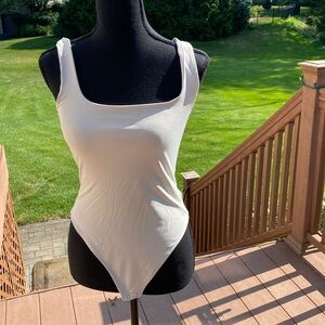 Beige stretchy bodysuit. Size M. NWOT. Sleeveless scoop neck.